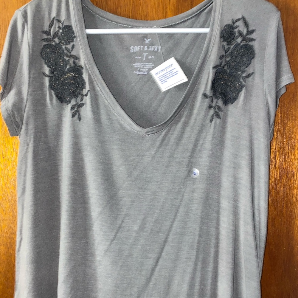 grey shirt with black flowers
